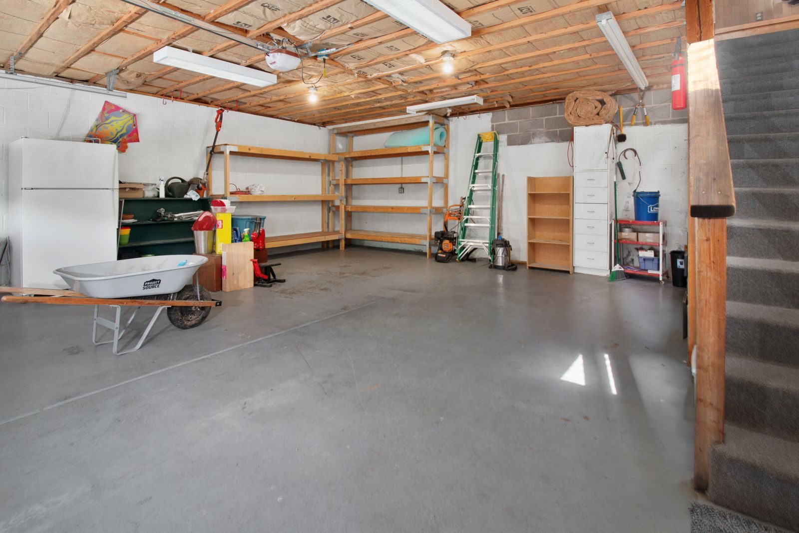 Garage front section kept as storage with shelving behind the original door